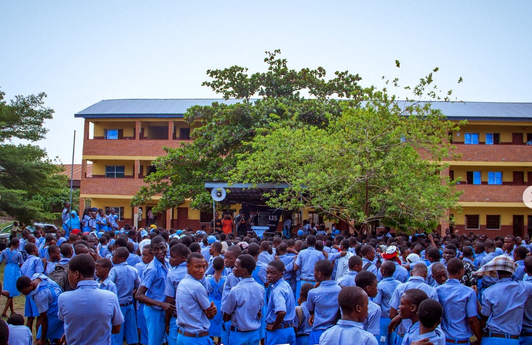 Students gathered beneath a tree on the Ajara Grammar School grounds