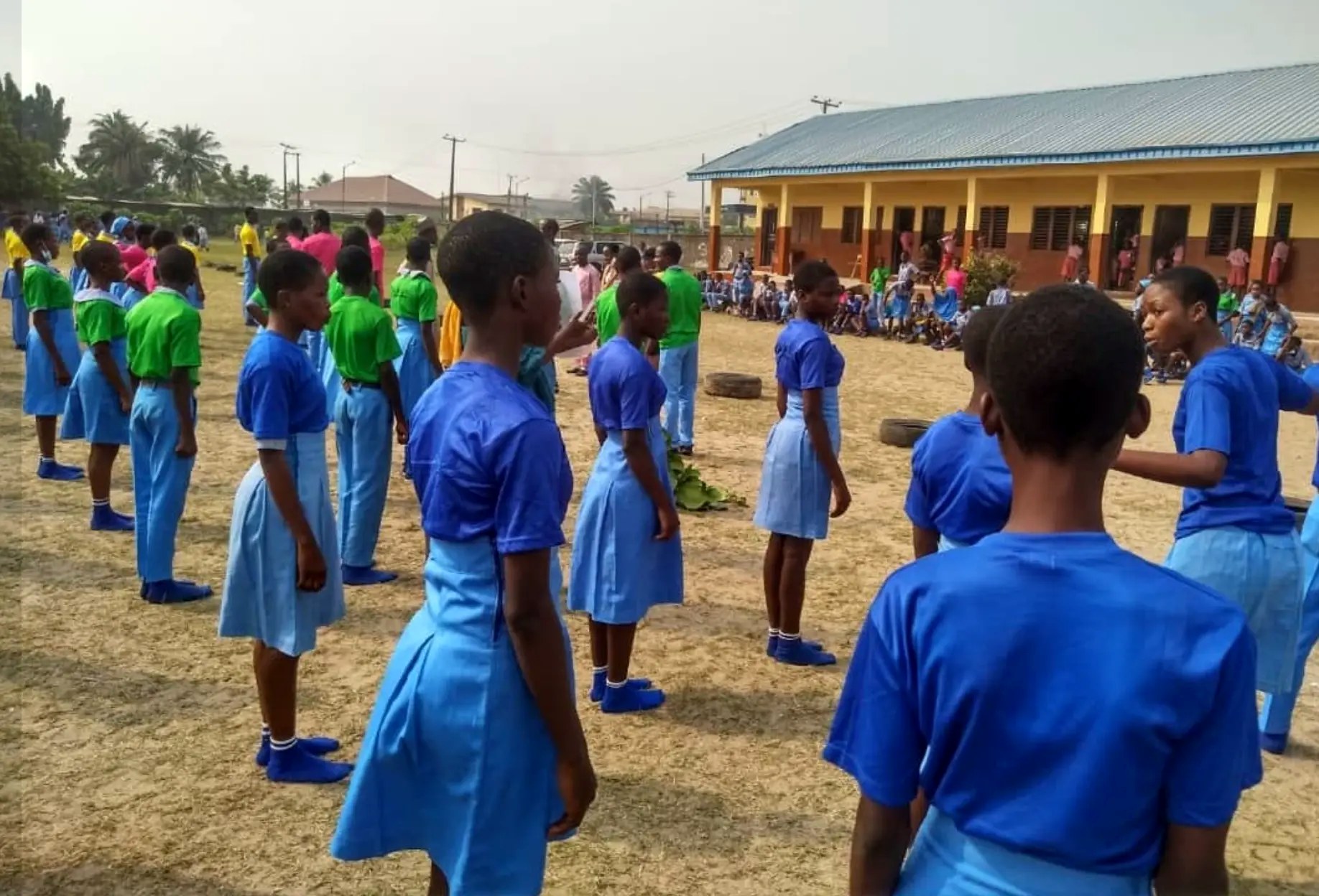 Ajara students in blue uniforms and coloured sports clothing on the school field