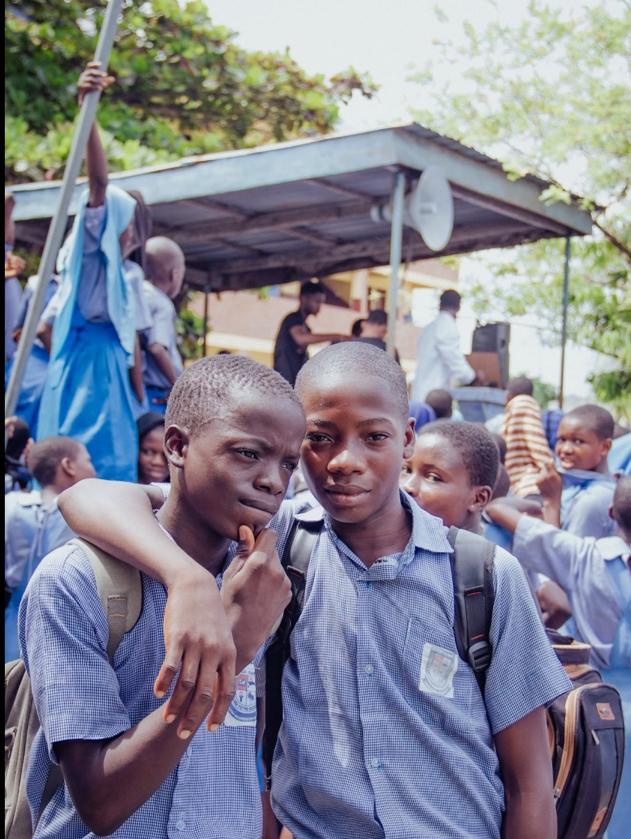 Two Ajara students in checked school uniforms during a school gathering
