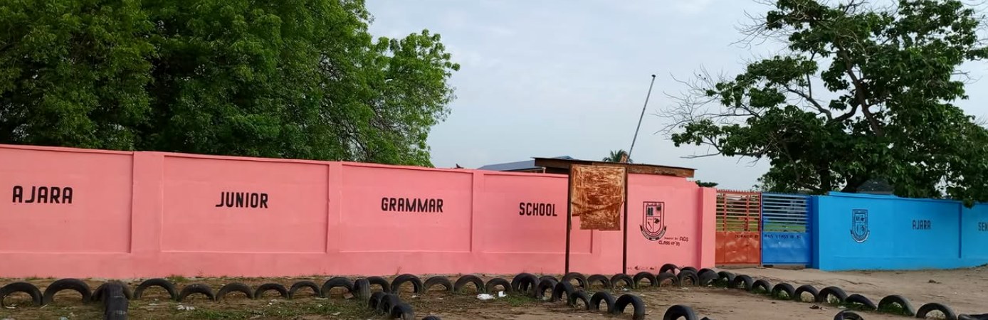 Pink wall bearing the name Ajara Junior Grammar School